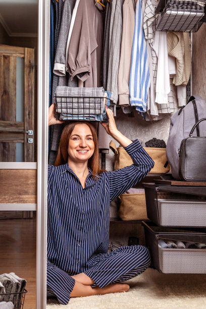滑稽的家庭主妇穿着睡衣摆着生态金属篮子，用来储存季节性的衣柜清洁图片下载