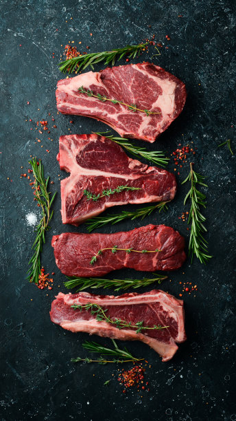 各种生的黑色安格斯牛排:t-bone, striploin, Rib eye，纽约牛排。前视图。以石头为背景。图片下载