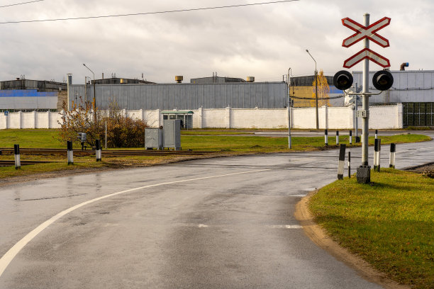 这张照片拍摄的是城市外的一条道路，在建筑物的背景下与铁路交叉图片下载