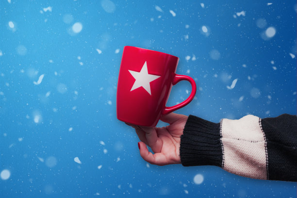 红色圣诞杯与蓝色的雪背景。图片下载