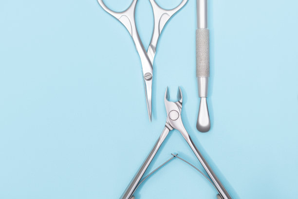 俯视图的美甲设备集。女性指甲护理设备。美甲和足疗设备在蓝色背景。副本的空间。图片下载