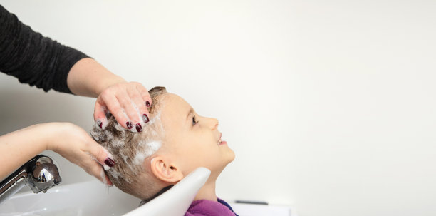 近距离的男孩/小孩坐在美发沙龙里图片下载