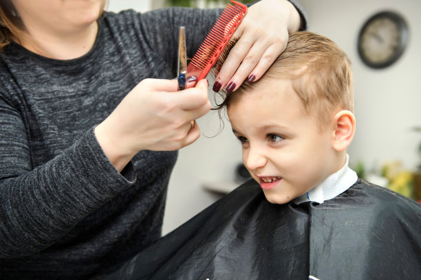 近距离的男孩/小孩坐在美发沙龙里图片下载