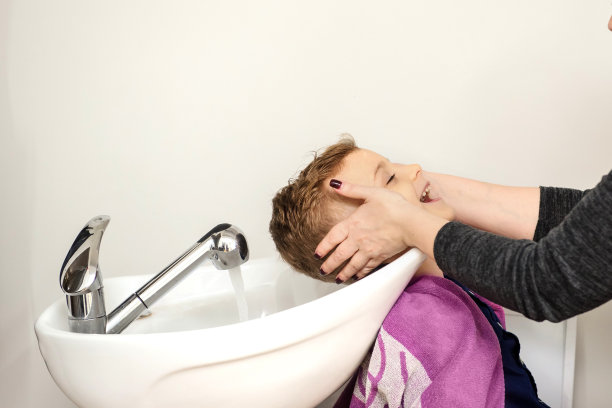 近距离的男孩/小孩坐在美发沙龙里图片下载