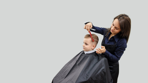 近距离的男孩/小孩坐在美发沙龙里图片下载