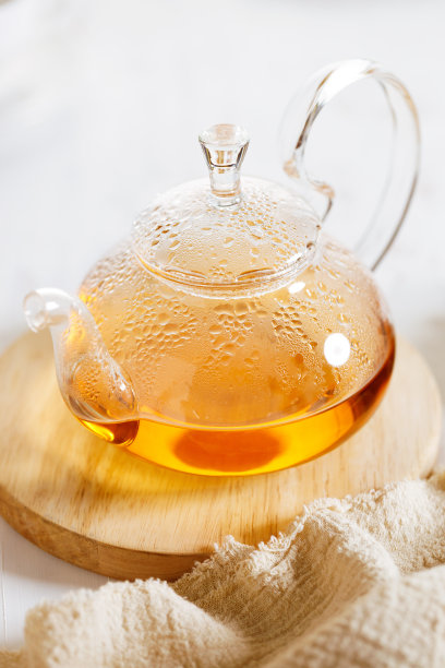 玻璃茶壶与蒸汽在木制板。图片下载