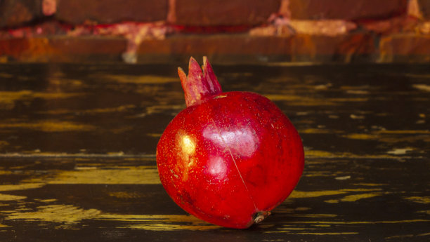 鲜嫩多汁的石榴放在红砖墙的背景上。熟透的红石榴的特写镜头。图片下载