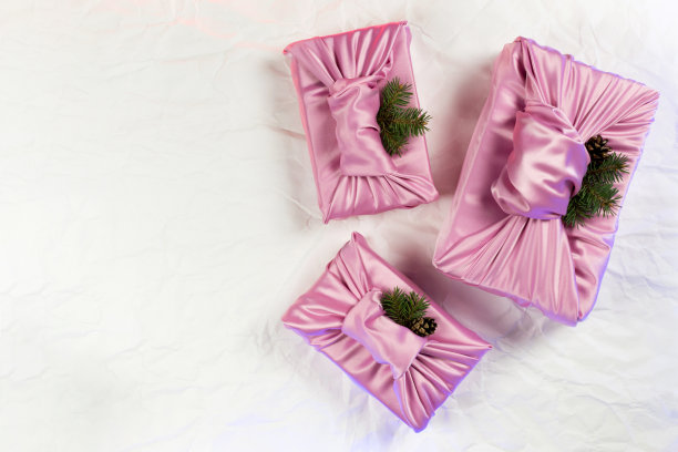 日本人用布裹樱，传统上用来运送礼品。粉红色的布和绿色的冷杉和松果。图片下载