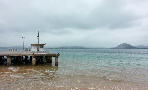 阴天海滩上的旧木码头图片下载