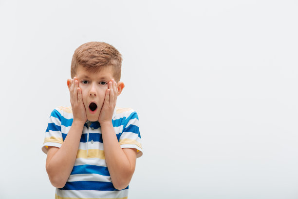 近距离拍摄的小男孩惊讶地看着相机，表情震惊，图片下载