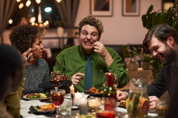 一个男人在和朋友吃饭时开玩笑图片下载