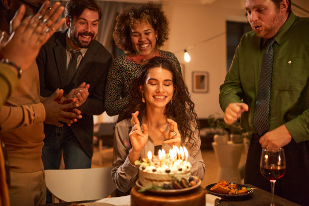 一个女人在吹灭蛋糕上的蜡烛前许了个愿图片下载