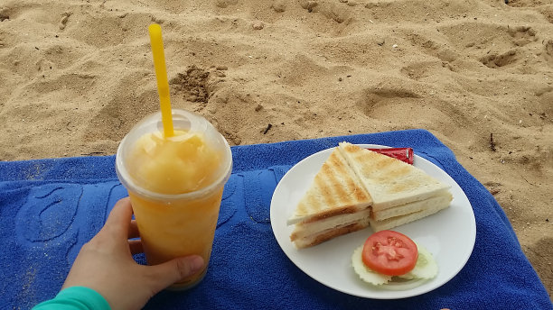 在海滩上享用饮料和三明治图片下载
