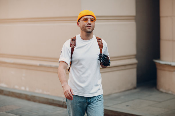 穿着便服，戴着假手的年轻残疾人走在阳光明媚的城市户外街道上。图片下载