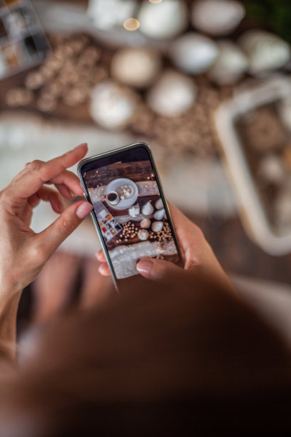 女人双手用手机拍着手工制作的圣诞树的圣诞构图图片下载