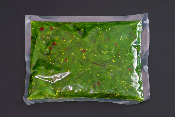 丘卡海藻沙拉在真空包装上一个黑色的背景特写。图片下载