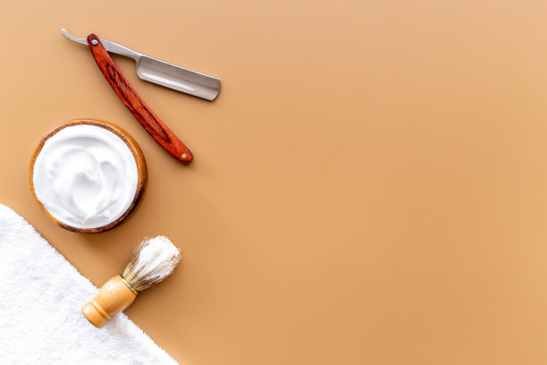 刷泡沫剃须刀和剃须泡沫在木碗，俯视图图片下载