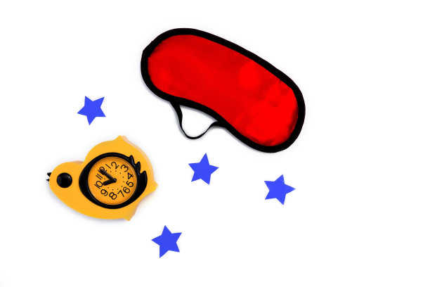 红色睡眠面具，黄色闹钟，白色背景。失眠，休息和健康睡眠的概念。平躺图片下载