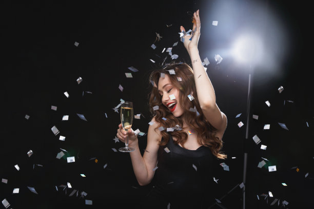 快乐美丽的年轻女人喝香槟和跳舞图片下载