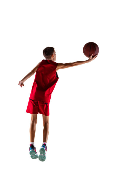 男孩的全长肖像，篮球运动员训练，把球扔进孤立的篮子在白色的背景。后视图图片下载