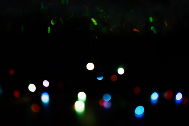在黑色背景上的彩色散景。明亮模糊的节日灯光纹理。图片下载