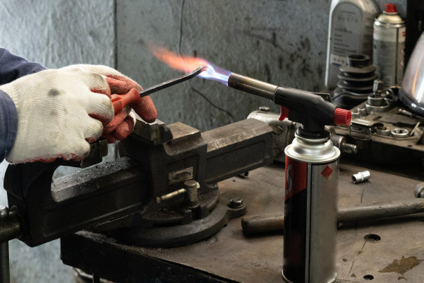 煤气灶和金属熔化的照片。男人们在车库戴着工作手套图片下载