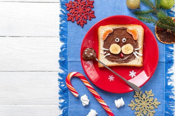 孩子们把新鲜水果和巧克力做成的老虎形状的三明治放在一个有复制空间的盘子里。新年，圣诞食物。前视图。图片下载