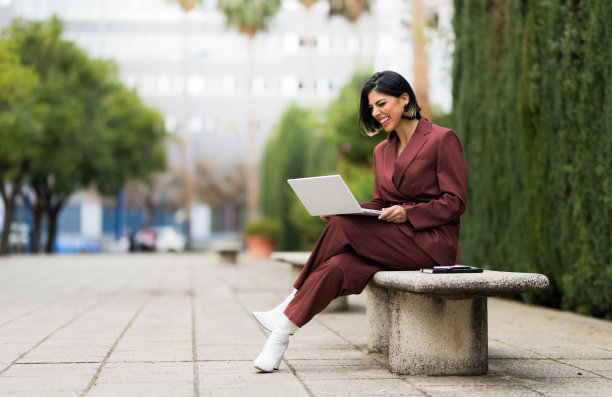 一个成功的商人在大街上用她的笔记本电脑工作图片下载