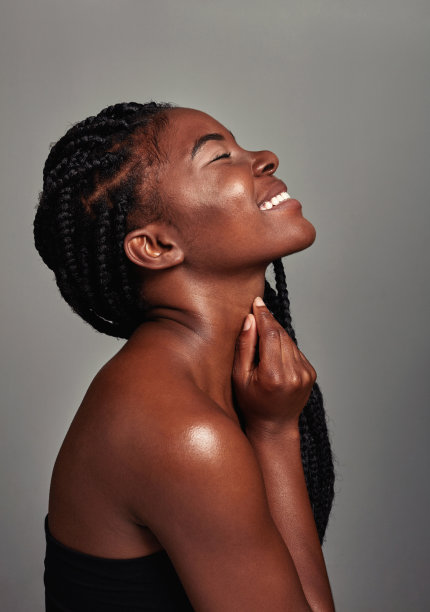 一个迷人的年轻女子在灰色背景下摆姿势的工作室拍摄图片下载