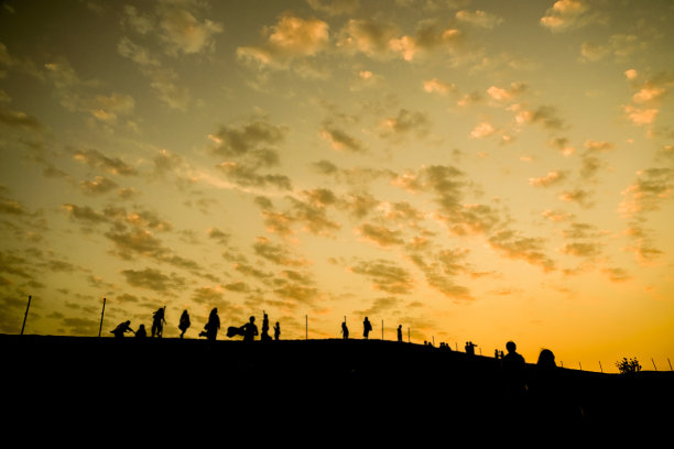 阿拉伯沙漠中的黄昏与人群轮廓图片下载