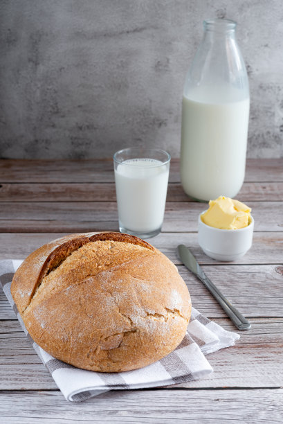 木制桌子上的圆形全麦面包。垂直拍摄。图片下载