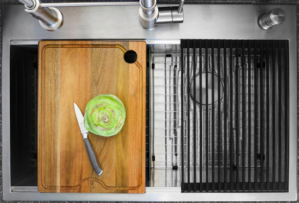 大头菜蔬菜准备在切板上切，这是工作站厨房水槽的一部分与工业龙头图片下载