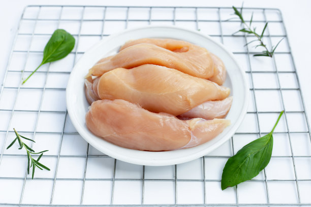 在白色背景上的盘子里的生鸡肉。图片下载