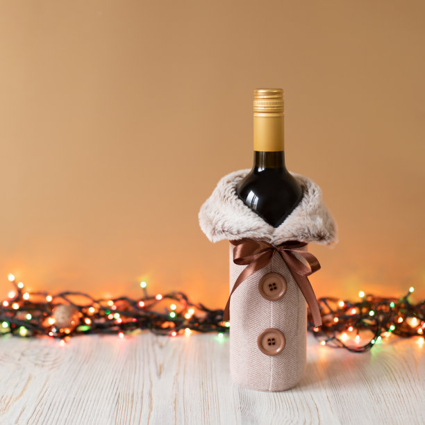 酒瓶装饰。服装外套与人造毛皮和钮扣葡萄酒酒瓶在金木材背景与圣诞灯花环。前视图，方照片，复制空间图片下载