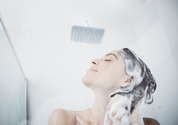 一个女人在淋浴时洗头发图片下载