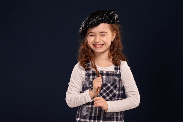 时尚的褐发小孩是在一个黑色背景的工作室摆姿势。孩子们的时装图片下载