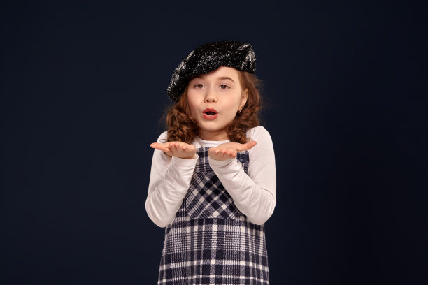 时尚的褐发小孩是在一个黑色背景的工作室摆姿势。孩子们的时装图片下载