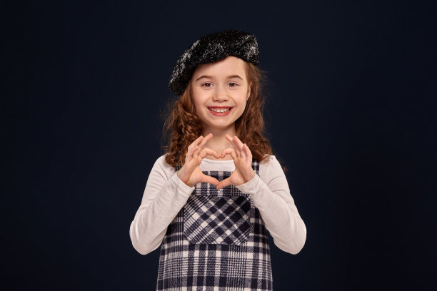 时尚的褐发小孩是在一个黑色背景的工作室摆姿势。孩子们的时装图片下载