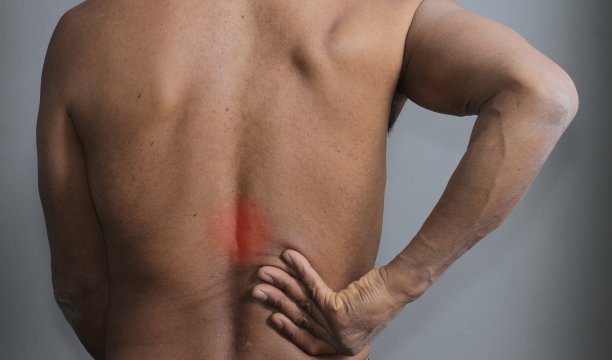 背痛不适拉肌肉与灰色背景股票照片图片下载