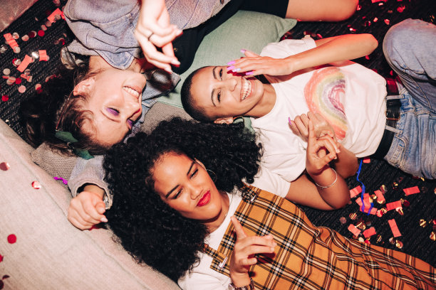 高角度的观点，快乐的朋友躺在地板上在一个聚会图片下载