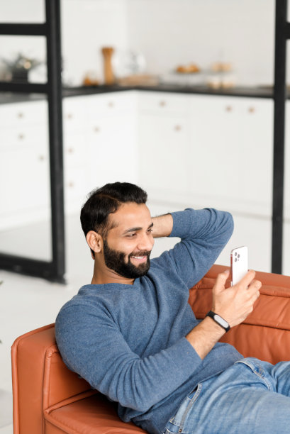 竖版照片：印度男人在家中舒适的沙发上休息图片下载