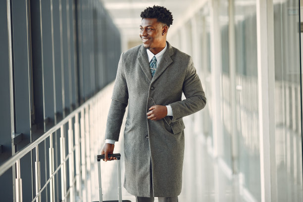 一位优雅的黑人男子在机场提着一个手提箱图片下载