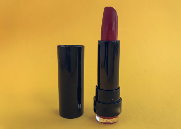 口红在一个黑色紧凑型包装在一个粉红色哑光的背景。鲜红的口红。时髦而多汁的颜色适合女孩的嘴唇。在嘴唇上创造一种光泽图片下载