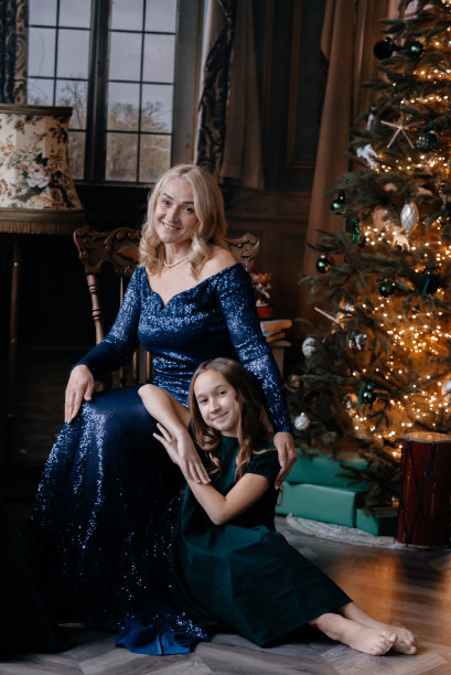 妈妈和女儿正在庆祝圣诞节。新年室内，冷杉树。家庭照片。图片下载