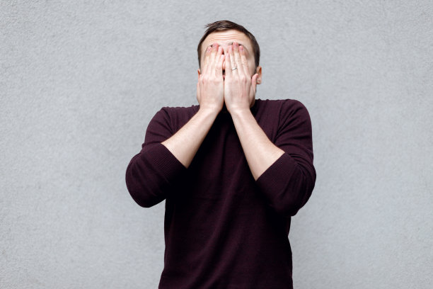 一个金发成熟男人用手捂着脸的工作室特写图片下载