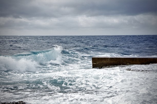 波浪翻滚着，以地平线为背景的小石墩。克罗地亚海岸线上亚得里亚海的波浪，背景是地平线。图片下载