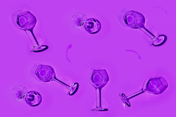 紫罗兰色背景的白葡萄酒或香槟杯。平的风格。图片下载