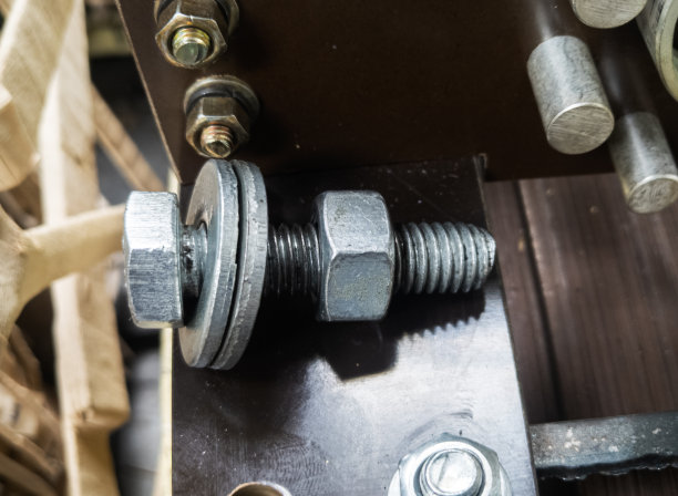 用螺栓固定在金属表面的螺母的特写镜头。图片下载