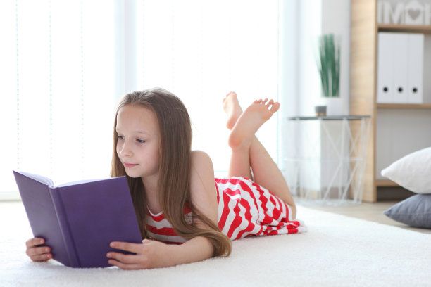 小女孩在家里看书。图片下载