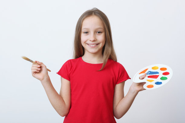 可爱的小女孩在家里画画。图片下载